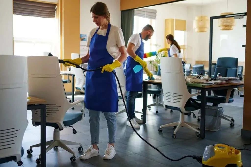 The Clear Choice cleaning crew in branded aprons cleaning a workspace with professional equipment.